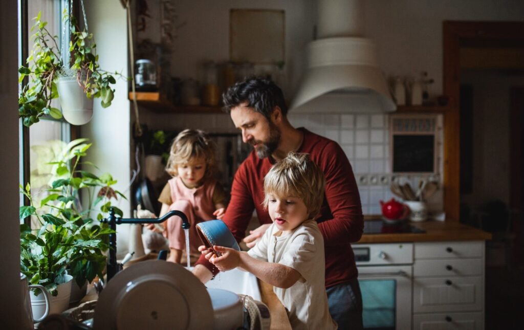 father with two small children washing dishes