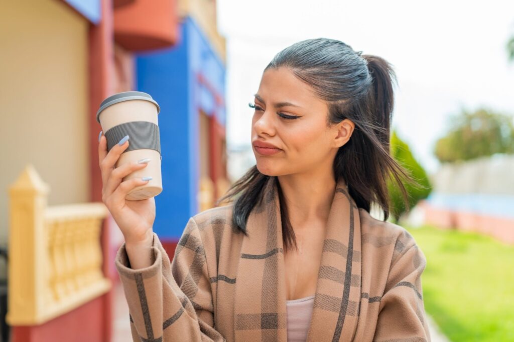Unhappy woman looking at her coffee cup
