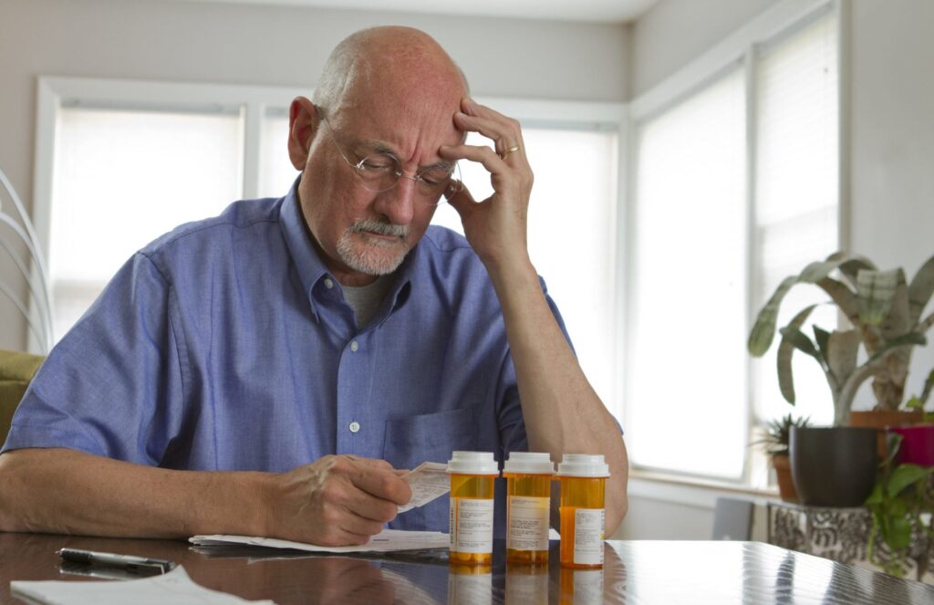 An older man stresses over prescription drugs