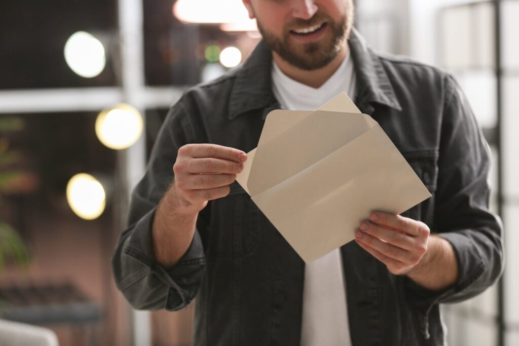 Man holding envelope with greeting card