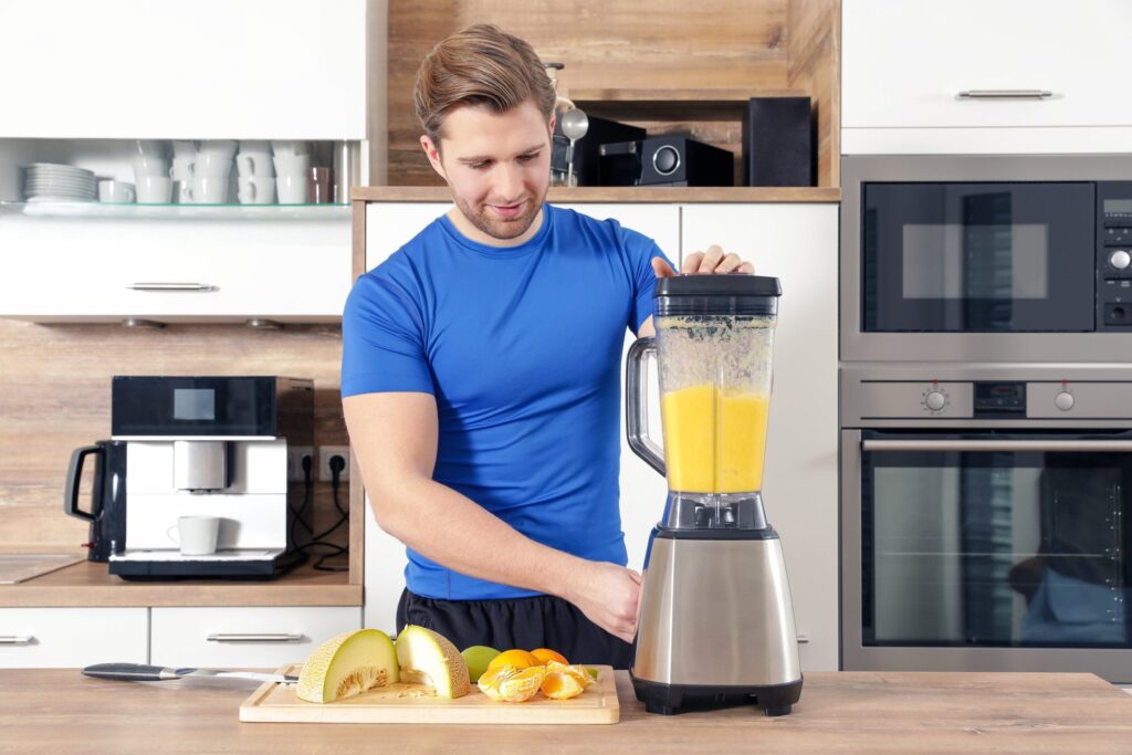 Man making a fruit smoothie in a blender
