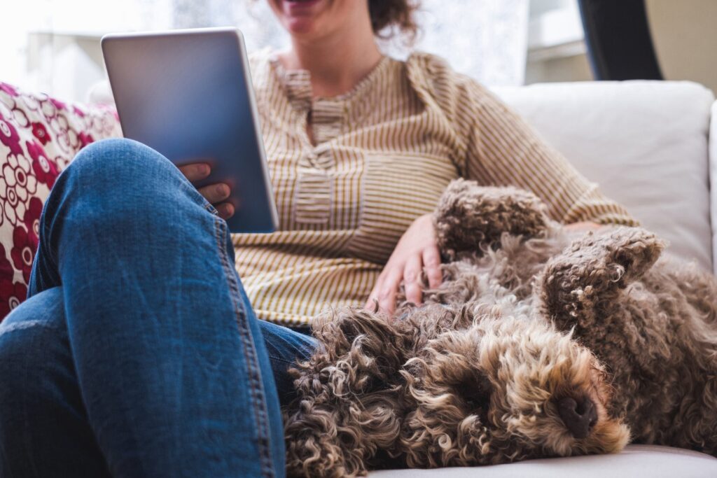 Woman reading on a tablet with her dog
