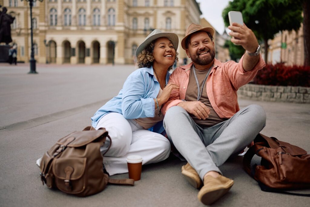 A traveling couple takes a selfie in a plaza.