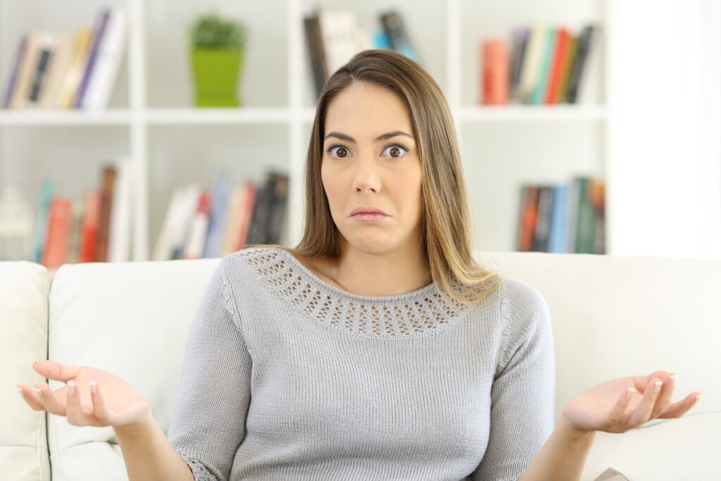 5 ‘Old School’ Money Habits That Are Actually Costing You Confused woman shrugging her shoulders