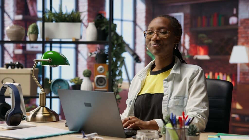 New Report Shows Shift in Remote Work. Here’s What to Expect in 2026. Happy woman working remotely from home on a laptop at a desk in a home office.