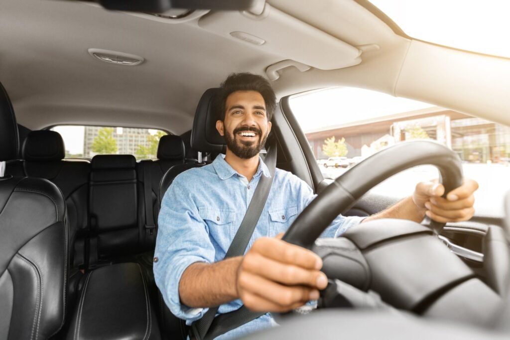 Smiling man driving his car.