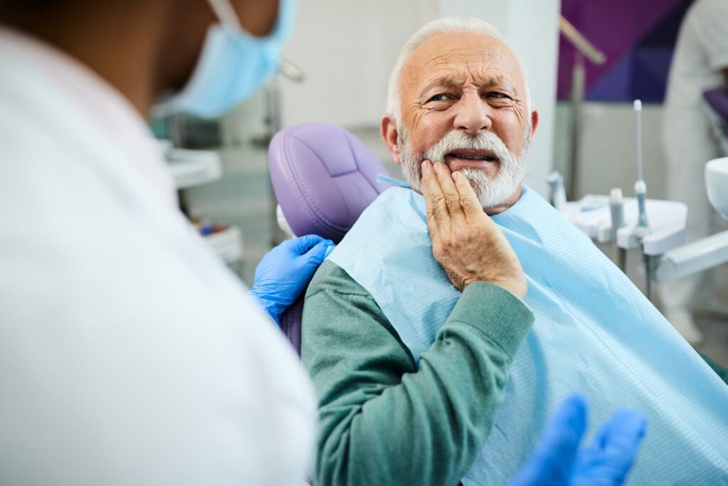 Senior with a toothache at the dentist