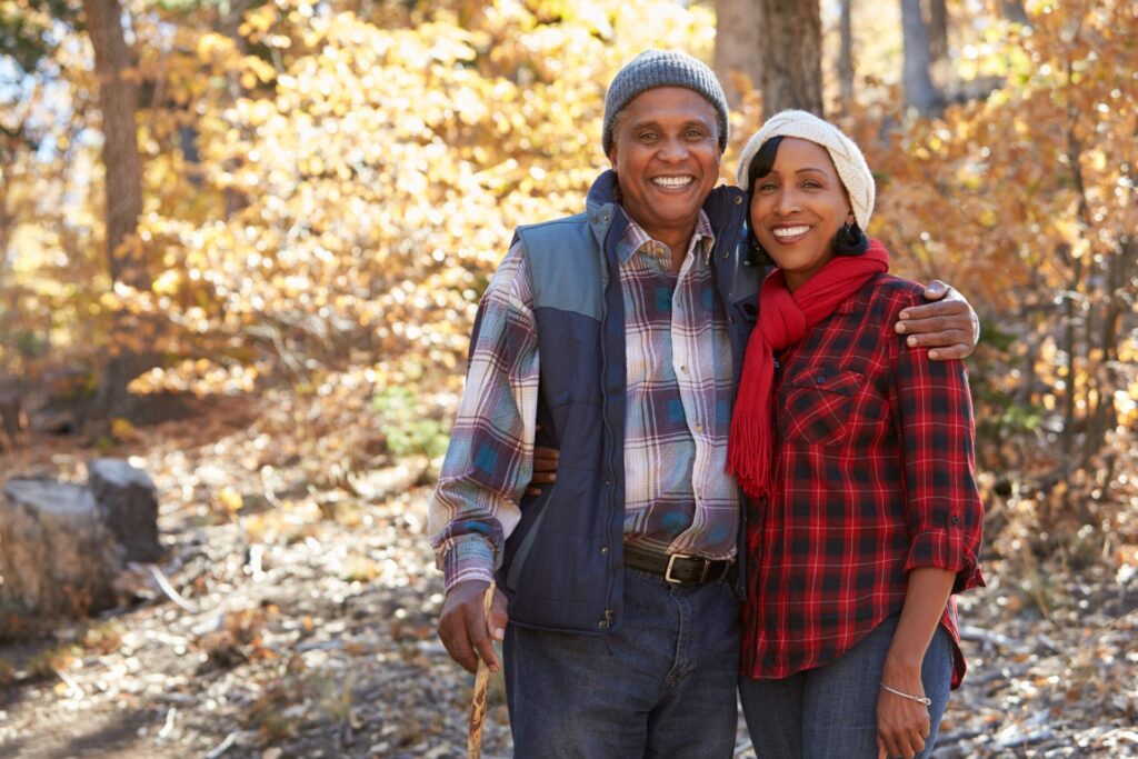 Happy senior couple walking through the woods