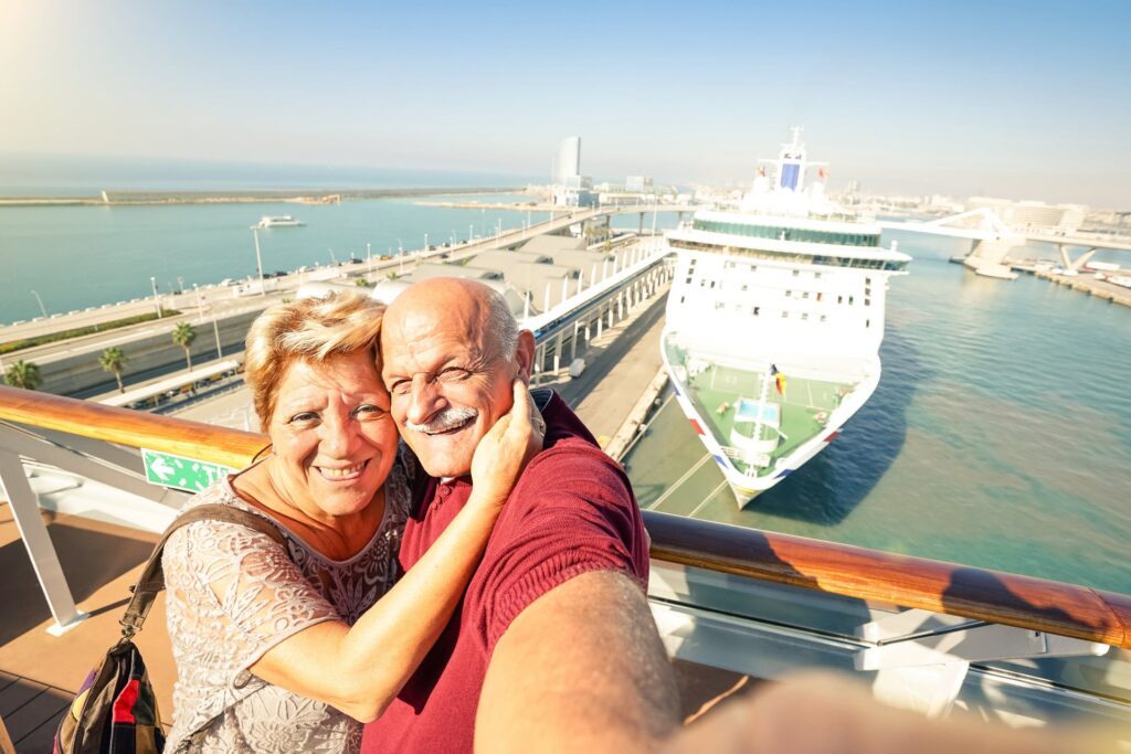 How to Get Senior Discounts on Cruises Senior couple taking a selfie on deck of a ship.