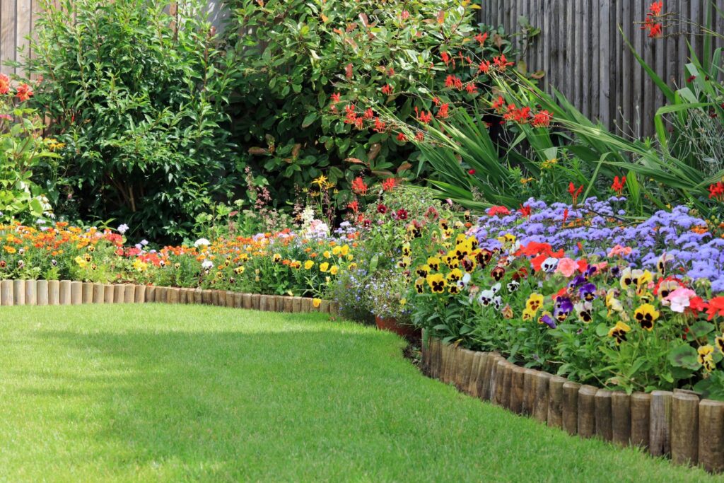 10 Tips to Thicken Your Lawn and Improve Its Overall Health Flower bed with edging in a backyard with a green lawn