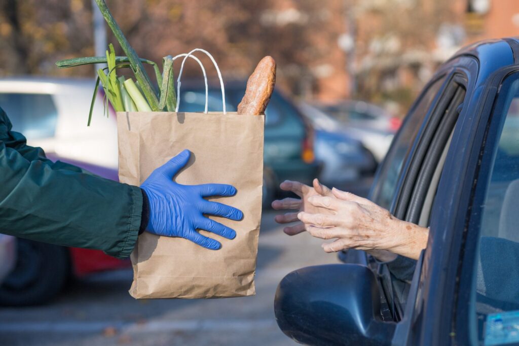 How to Skip the Grocery Store Aisles (and Hefty Delivery Fees) Elderly woman receiving free groceries or grocery delivery or curbside pickup