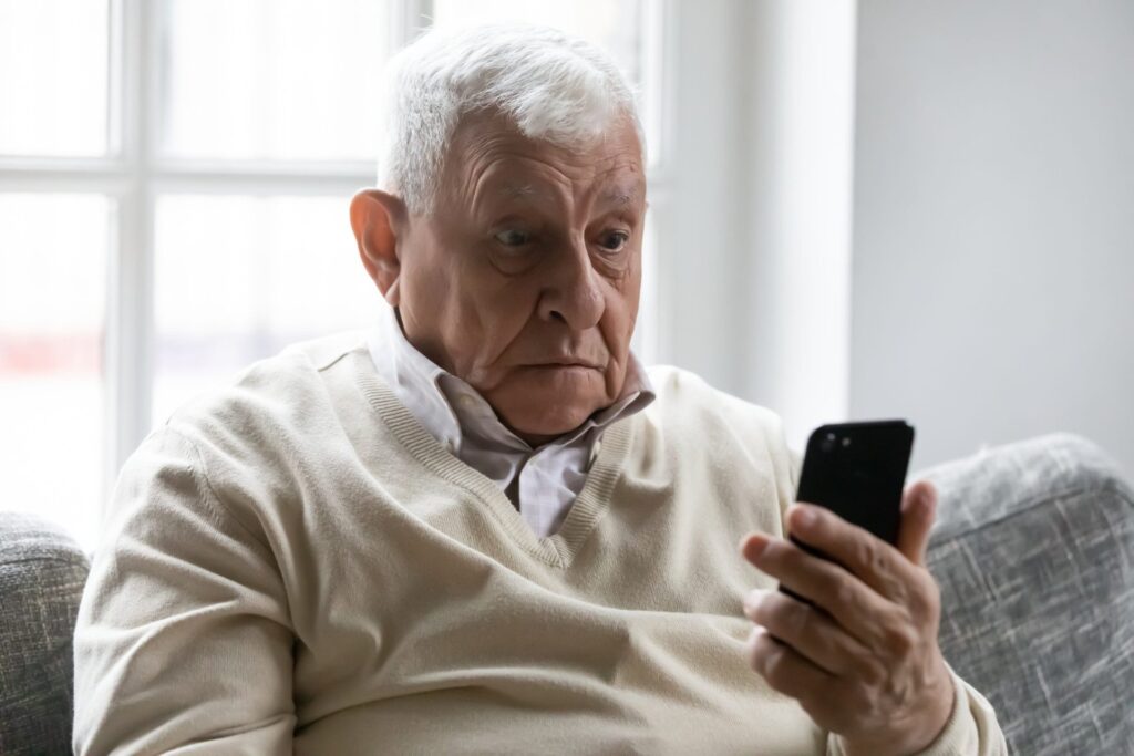 Surprised senior holding a smartphone