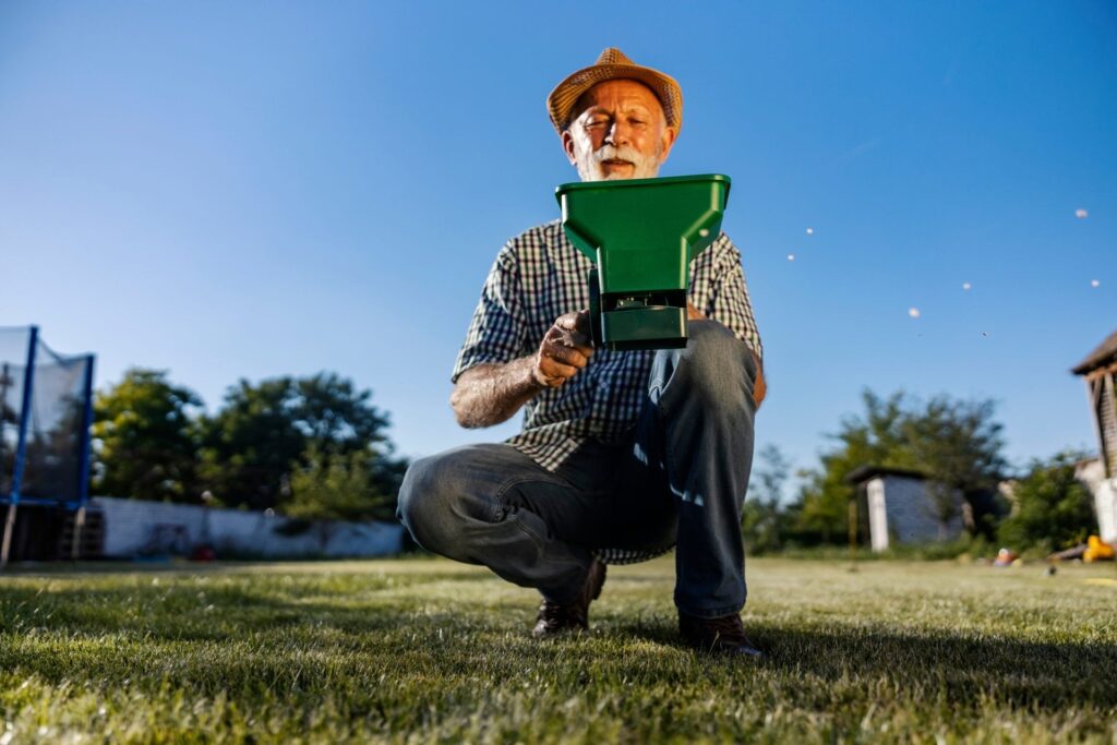 Senior man fertilizing lawn
