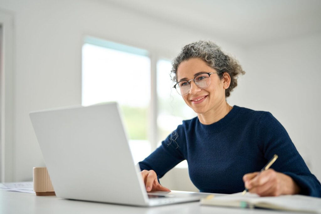 9 Free Career Aptitude Tests to Help You Find a Fulfilling Job Happy middle-aged woman sitting at table at home office using laptop to work remotely