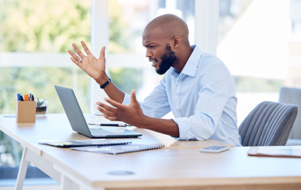 Angry man looking at his laptop