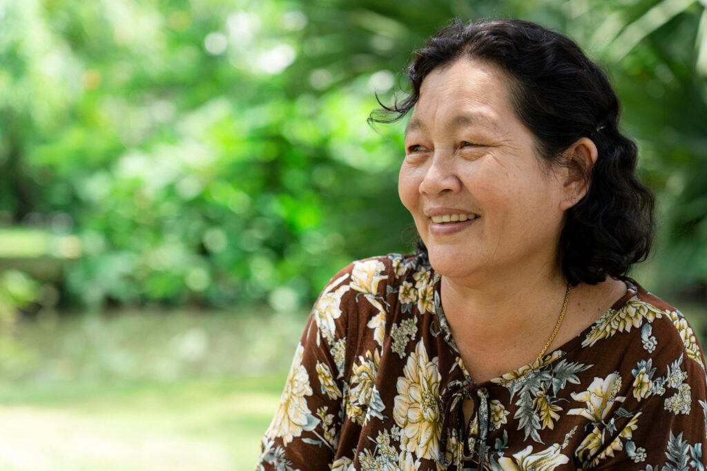 Happy woman smiles and enjoys sitting outside.